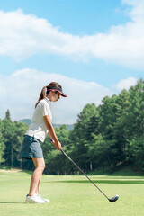 Female golfer playing golf on a golf course (tee shot, golf competition)
