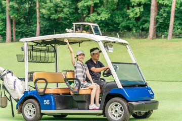 Male and female golfers riding golf carts at a golf course