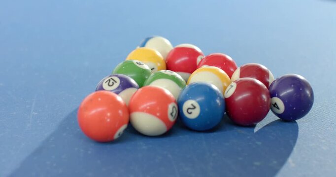Camera is moving back tilting up, revealing rack of billiard balls on blue pool table