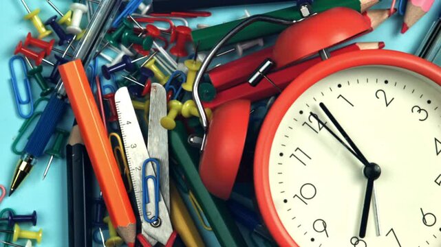 The alarm clock falls on school tools. Filmed on a high-speed camera at 1000 fps. High quality FullHD footage