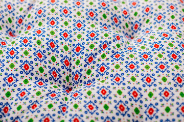 Bright textile pattern with colorful geometric floral motifs close up