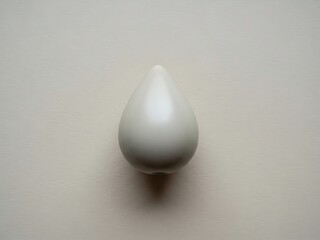 Fototapeta premium Minimalist composition of sleek teardrop shape on neutral textured surface