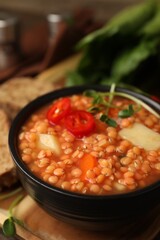 Delicious lentil soup with vegetables served on table, closeup