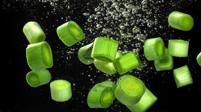 Sliced leeks fall under water. Filmed on a high-speed camera at 1000 fps. High quality FullHD footage