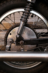 Close-up of the wheels of a vintage motorcycle.