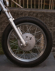 Close-up of the wheels of a vintage motorcycle.