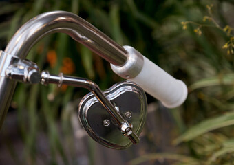 A close-up of the heart-shaped rearview mirror of a vintage motorcycle.