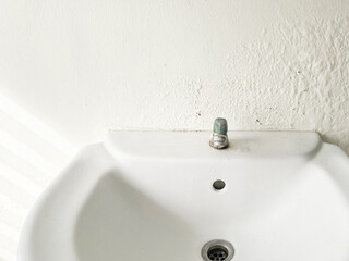 Broken Washbasin on Damped, Musty Old Painted Wall with Sunlight. Textured Exterior Toilet Wall in Room at Dhamma Retreat Center, Saraburi, Thailand. 25 OCT 2025. A.M. © Ravie's factory