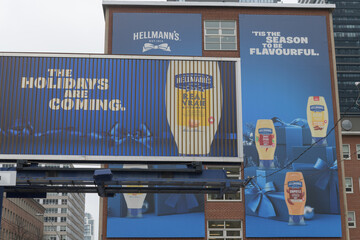 Fototapeta premium various billboards with Hellmann’s Real Mayonnaise or condiment products on display near Church St and Bloor St E, Toronto