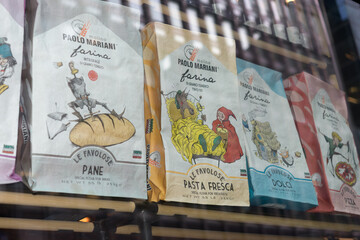 Naklejka premium Italian flour sacks from Molino Paolo Mariani, decorated with playful illustrations for bread, fresh pasta, sweets, and pizza, inside window at Sud Forno, a restaurant, 132 Yonge St, Toronto