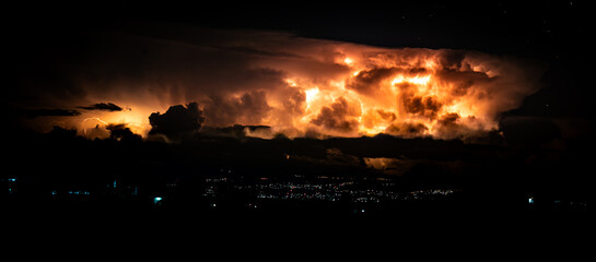  Stormy night sky with illuminated clouds