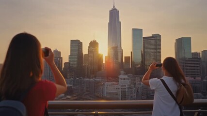 Adventurous travelers exploring a vibrant city skyline during sunset, pulling luggage and capturing photos, perfect for travel and tourism campaigns