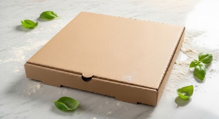 A closed cardboard pizza box sits on a marble surface surrounded by basil leaves and flour.