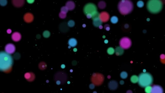 Abstract colorful bokeh particles floating on black background. Blurring light dots in red, green, blue, and purple moving slowly for festive, magical, or disco overlay effect.