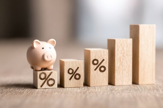 Close-up of wooden blocks with percentage symbols decreasing in size, piggy bank on the table representing saving or financial growth concept