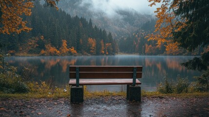 Empty wooden bench by a lake in autumn