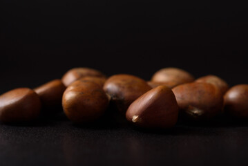 Roasted chestnuts on black background, healthy snack to eat in autumn