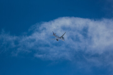 Airplane Flying Above Soft White Clouds – Blue Sky Aviation Travel Photo
