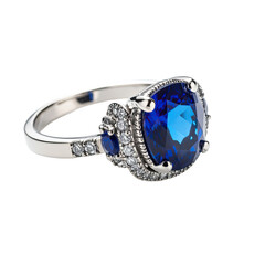 Blue gem ring with accent stones on silver band. Detailed
