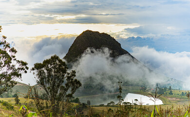 Cloudy landscape of an Andean sunset. Mountain surrounded by mist. Cornfield in the mountains.
