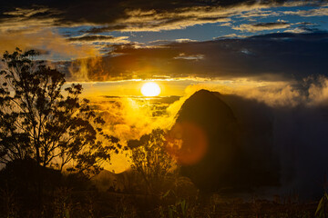 A beautiful sunset over an Andean landscape with clouds. The last rays of the sunbathe the Andean...