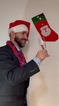 hombre en navidad bebiendo, brindando y bailando con copa y gorro de papa noel