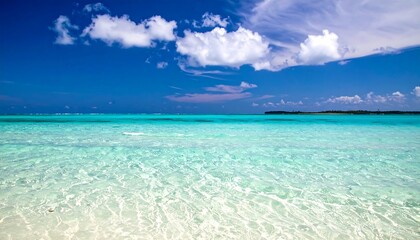 Clear turquoise water with white clouds in the bright blue sky