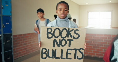 Portrait, school shooting and boy with sign, protest and education with placard, activism and serious. Gun violence, student or child in hallway, human rights or banner to promote safety or knowledge © MagicDavid25/peopleimages.com
