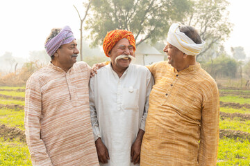 Happy rural indian farmer friends laughing. Smiling senior male friends wearing traditional kurta having fun together. People of india. Mental health. Stress free. Happiness. Village life.