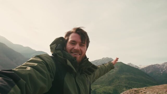 Young traveler vlogger recording video on phone in mountains smiling speaking to audience concept of joy freedom storytelling mindful travel authentic lifestyle emotional connection