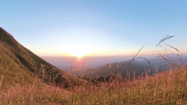 
Zoom out effect of 4k sunset blue sky scene on the top of mountain with grass foreground 