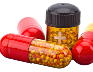 Capsules and pills in transparent jar with orange tint on a dark background