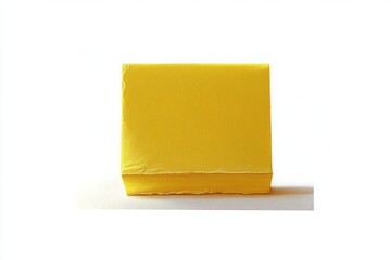 Small rectangular yellow box with a slightly textured surface sitting on a white background casting a soft shadow