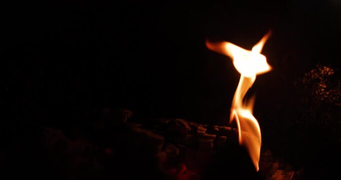 Warm and inviting close-up of a gently flickering flame against a dark background, creating a cozy and serene atmosphere highlighting the beauty of natural fire