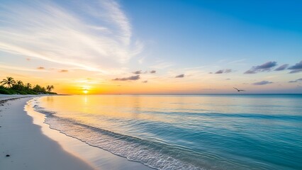 Sunrise over serene beach with clear turquoise water and a golden sky