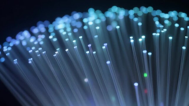 Futuristic digital network technology concept showing a close-up of glowing blue fiber optic cable ends for high-speed data transmission