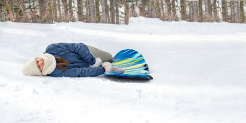 Girl lying on snowy ground  and enjoying winter fun