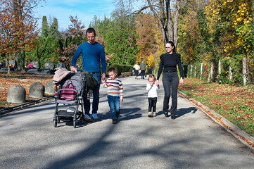 Young family at the cemetery for All Saints' Day