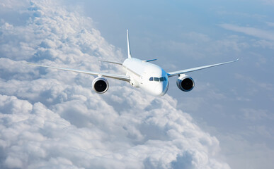 Obraz premium White passenger airplane flying in the sky amazing clouds in the background - Travel by air transport