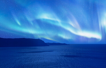 Aurora Borealis or Northern lights over the blue sea at night