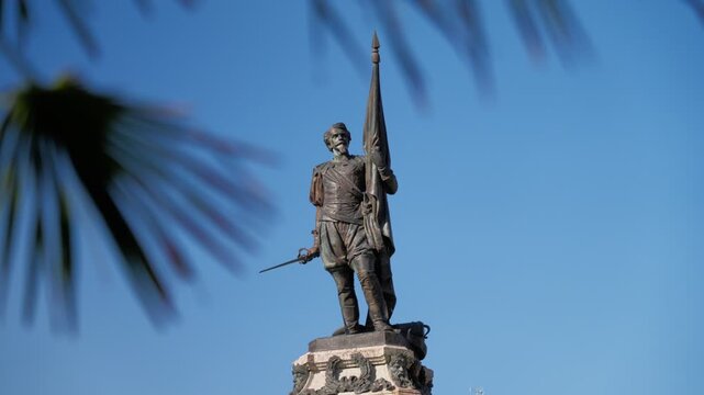 Bronze monument of Antonio de Oquendo set against a sharp, clear blue Basque sky.