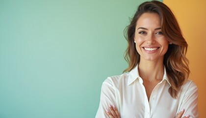 Smiling woman with brown hair wears white shirt. She stands against a teal and orange background. Her arms are crossed, showing confidence and professionalism.