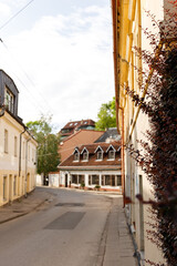 Beautiful city streets on a sunny summer day. Historic buildings among green trees in European city. 1 June 2025, Vilnius, Lithuania