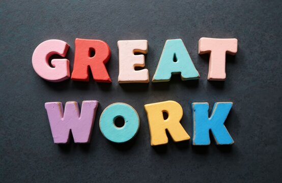 Bright colorful wooden letters spell out GREAT WORK on dark textured background. Word set gives positive feedback, motivation, recognition for success. Good for business, school, personal achievement