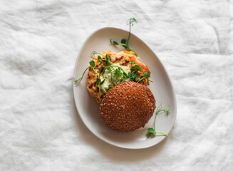 Homemade burger with omelet, grilled chicken patty, mustard mayonnaise sauce on a light background,...