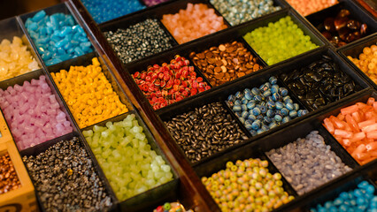 Vibrant collection multicolor craft beads neatly arrange in wooden organizer boxes compartment...