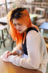 Asian happy beautiful cheerful outdoor portrait young woman light orange hair sitting posing relaxing outdoors in urban cafe, activity joyful travel fresh nature holidays lifestyle