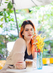 Asian happy beautiful cheerful outdoor portrait woman light orange hair smiling warmly among blooming bouquet flowers, Natural tree cafe greenery create cozy rustic garden joyful fresh nature concept