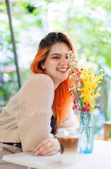 Asian happy beautiful cheerful outdoor portrait woman light orange hair smiling warmly among blooming bouquet flowers, Natural tree cafe greenery create cozy rustic garden joyful fresh nature concept