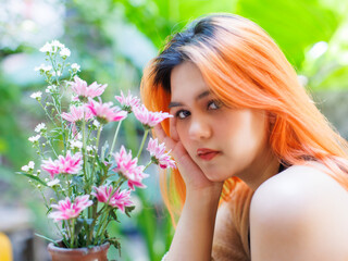 Asian happy beautiful cheerful outdoor portrait woman light orange hair smiling warmly among blooming bouquet flowers, Natural tree cafe greenery create cozy rustic garden joyful fresh nature concept